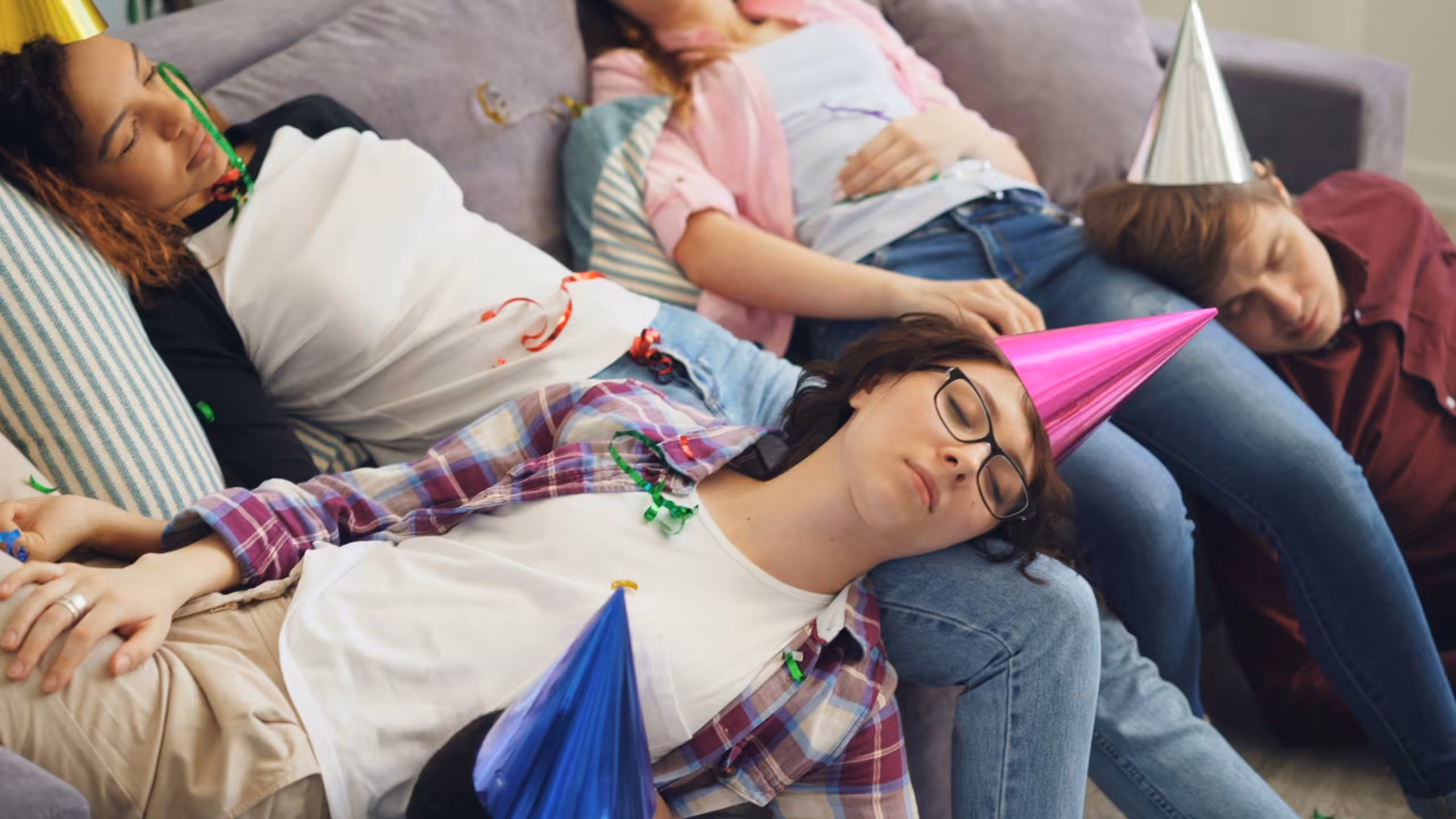 Kinder und Erwachsene schlafen erschöpft nach einer Feier auf einem Sofa