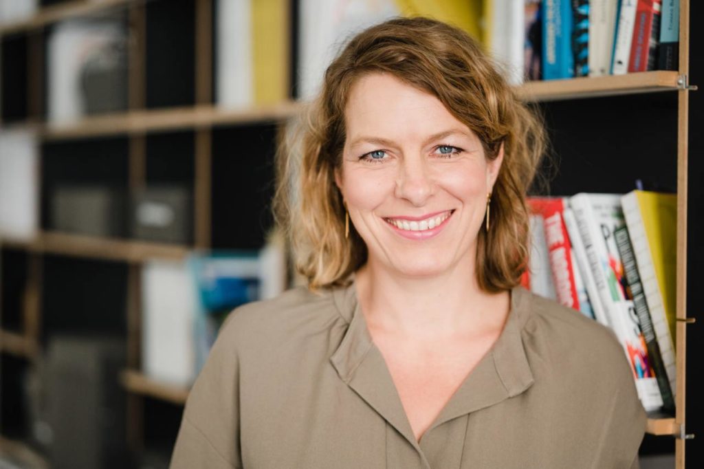Portrait von Anjet Sekkat vor einem Bücherregal